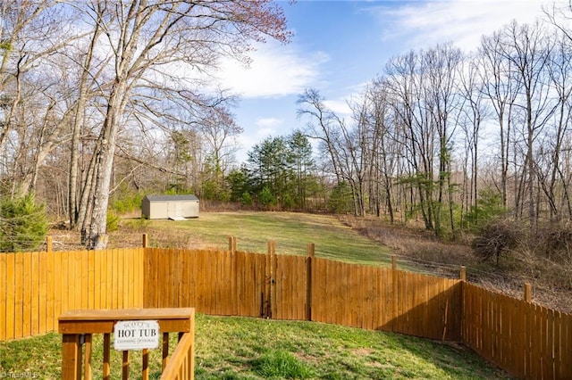 view of yard featuring a storage unit, an outdoor structure, and fence