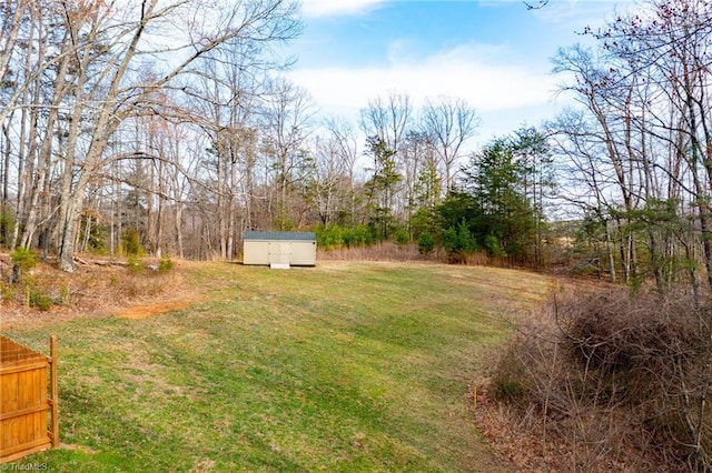 view of yard with a storage shed, fence, and an outdoor structure