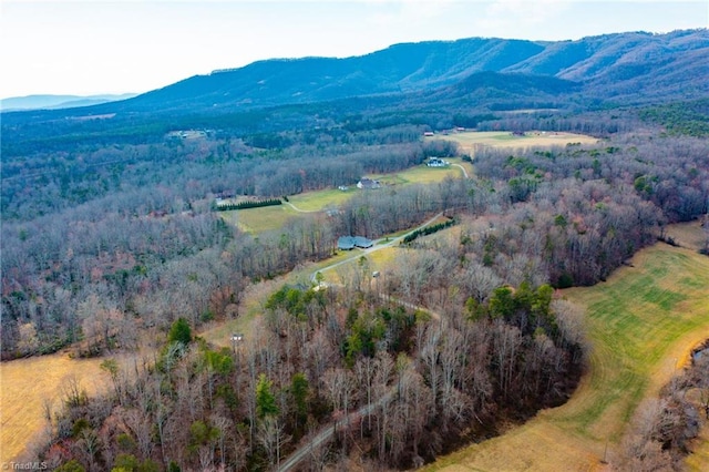 birds eye view of property with a wooded view and a mountain view