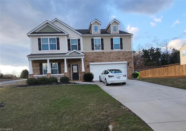 view of front facade featuring a porch, a front yard, and a garage