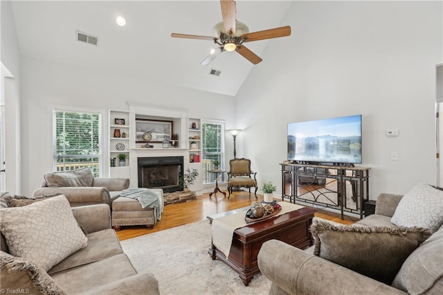 449 Wallburg High Point Rd, Winston-Salem, NC 27107 - living room with high vaulted ceiling, wood finished floors, a ceiling fan, and a fireplace with raised hearth