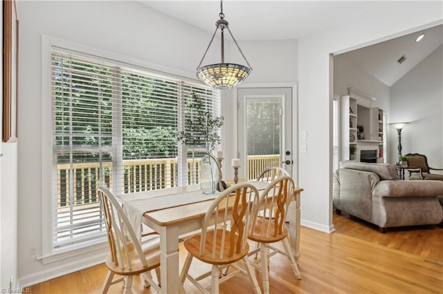 449 Wallburg High Point Rd, Winston-Salem, NC 27107 - dining space with light wood-style flooring, a fireplace, vaulted ceiling, and baseboards
