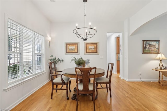 449 Wallburg High Point Rd, Winston-Salem, NC 27107 - dining space with light wood-style flooring, a chandelier, arched walkways, and baseboards