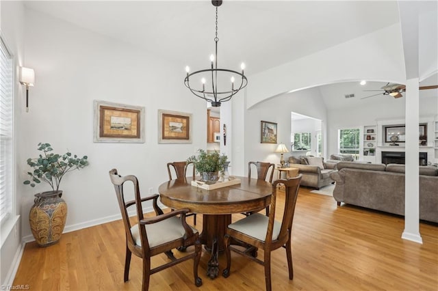 449 Wallburg High Point Rd, Winston-Salem, NC 27107 - dining space with arched walkways, a ceiling fan, vaulted ceiling, light wood-style floors, and a fireplace