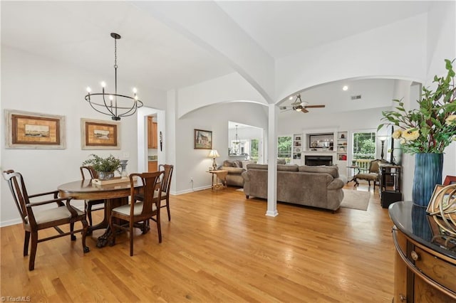 449 Wallburg High Point Rd, Winston-Salem, NC 27107 - dining room with arched walkways, a chandelier, a ceiling fan, light wood-style flooring, and a fireplace