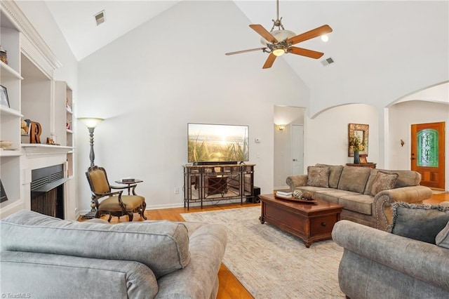 449 Wallburg High Point Rd, Winston-Salem, NC 27107 - living area with arched walkways, a ceiling fan, high vaulted ceiling, a fireplace, and wood finished floors