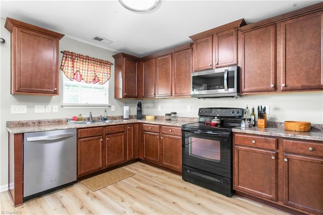kitchen with light wood-style floors, stainless steel appliances, visible vents, and a sink
