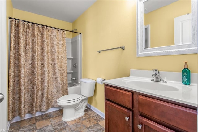 bathroom with shower / tub combo, stone finish floor, toilet, baseboards, and vanity