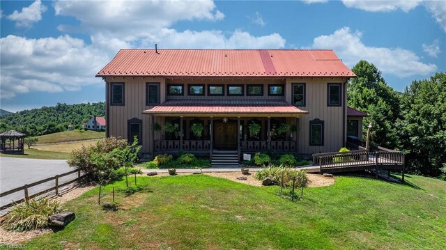 rear view of property with a yard and covered porch