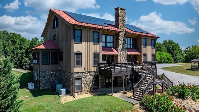 back of property featuring solar panels and a lawn