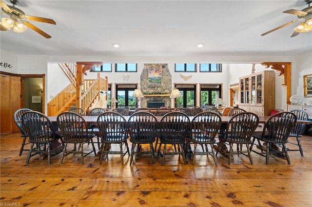 dining area featuring a fireplace, ceiling fan, and hardwood / wood-style floors