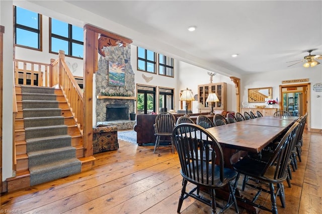 dining area with light hardwood / wood-style floors, a fireplace, and ceiling fan