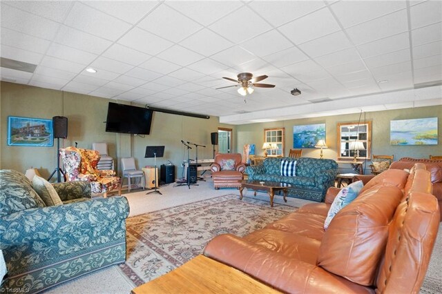 carpeted living room featuring a drop ceiling and ceiling fan