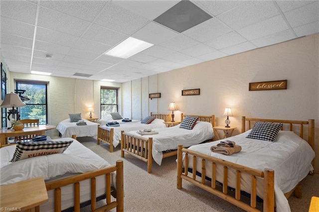 bedroom with carpet floors and a paneled ceiling