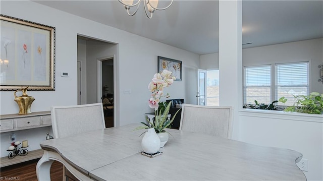 dining space with an inviting chandelier and dark wood finished floors