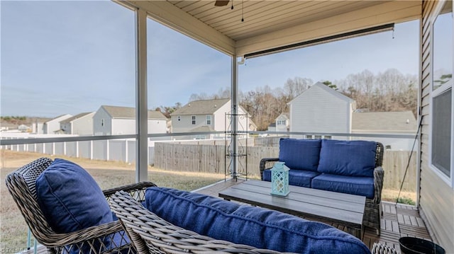 sunroom / solarium with a residential view and ceiling fan