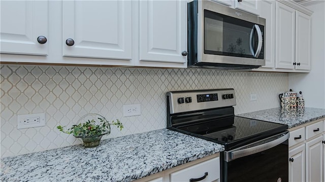 kitchen featuring white cabinetry, light stone counters, backsplash, and appliances with stainless steel finishes