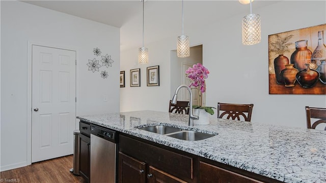 kitchen with a sink, pendant lighting, light stone counters, dark wood-style floors, and stainless steel dishwasher