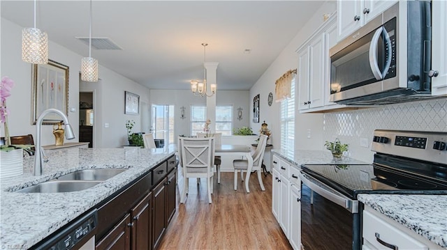 kitchen with visible vents, dark brown cabinets, stainless steel appliances, white cabinetry, and a sink