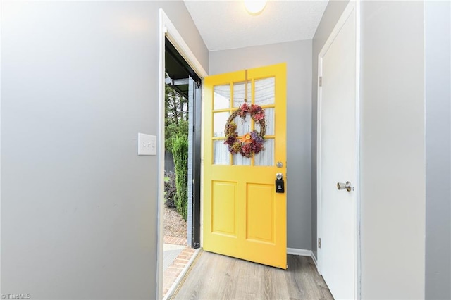 doorway to outside with light wood-style floors and baseboards