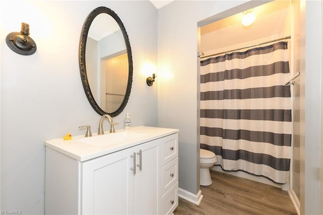 bathroom with wood finished floors, toilet, vanity, and a shower with shower curtain