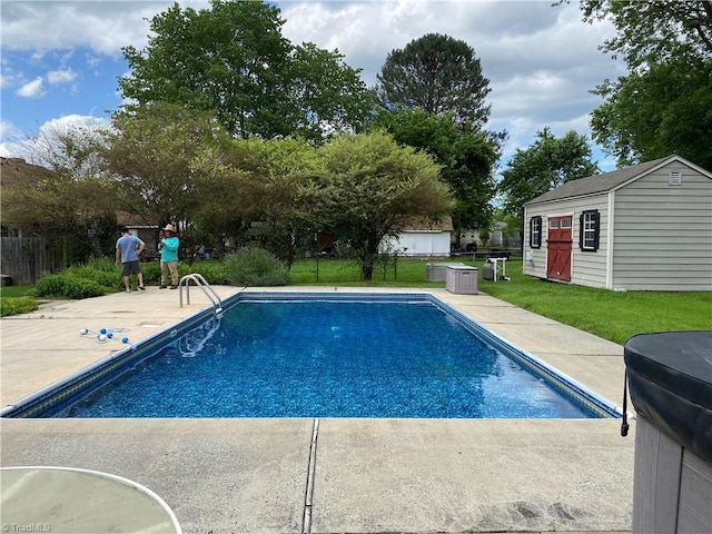 view of swimming pool featuring a yard, a patio area, and an outbuilding