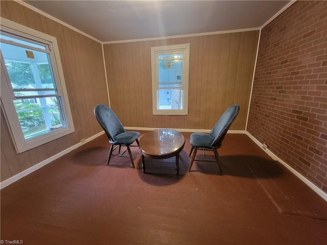 unfurnished room with wooden walls, ornamental molding, wood-type flooring, and brick wall