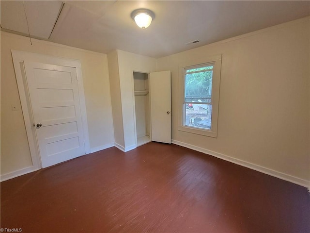 unfurnished bedroom with dark hardwood / wood-style flooring and a closet