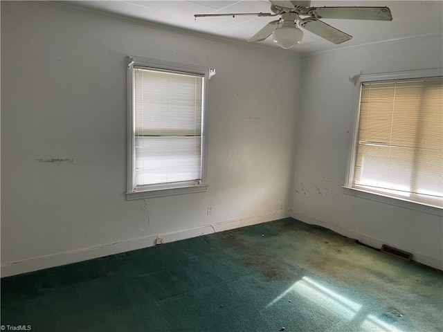 carpeted spare room featuring ceiling fan and crown molding