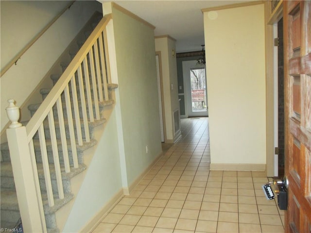 hallway featuring crown molding and light tile patterned flooring