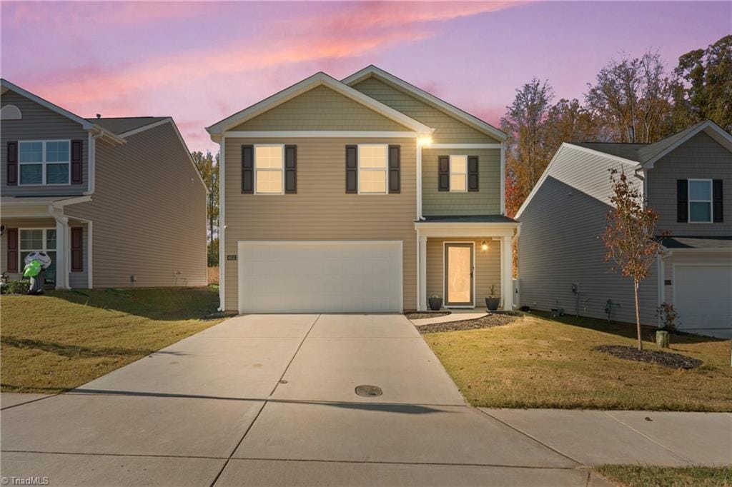 view of property featuring a yard and a garage