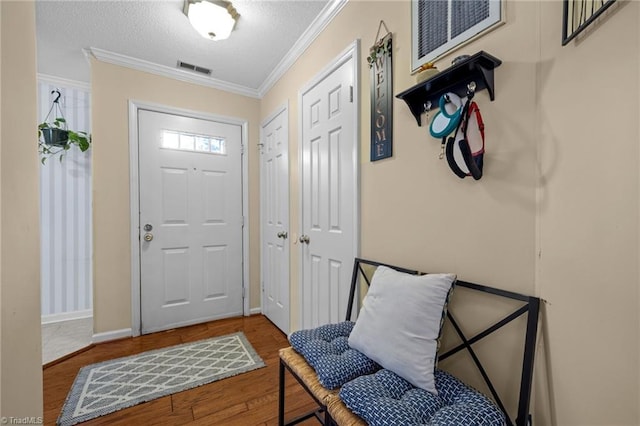 3100 Coachmans Way, Durham, NC 27705 - entryway featuring crown molding, wood finished floors, a textured ceiling, baseboards, and visible vents