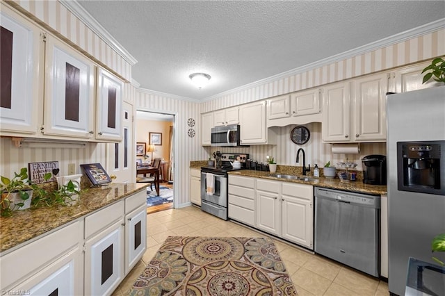 3100 Coachmans Way, Durham, NC 27705 - kitchen featuring dark stone counters, a sink, light tile patterned floors, stainless steel appliances, and ornamental molding