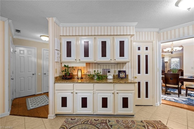 3100 Coachmans Way, Durham, NC 27705 - kitchen featuring an inviting chandelier, ornamental molding, light tile patterned flooring, dark stone counters, and a textured ceiling