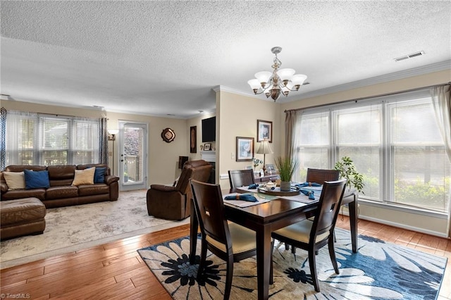 3100 Coachmans Way, Durham, NC 27705 - dining space featuring light wood-style flooring, visible vents, an inviting chandelier, and a textured ceiling
