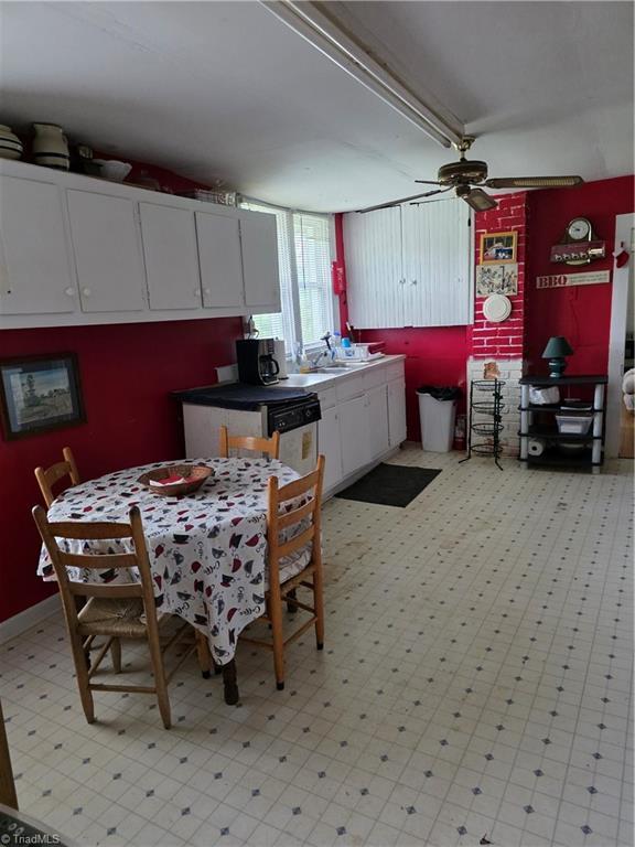 4793 Cheek Mountain Rd, Laurel Springs, NC 28644 - kitchen featuring white cabinets, ceiling fan, and light floors