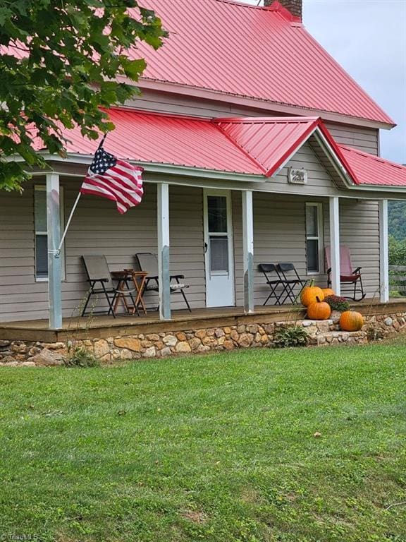 4793 Cheek Mountain Rd, Laurel Springs, NC 28644 - rear view of house with a chimney, covered porch, metal roof, and a lawn