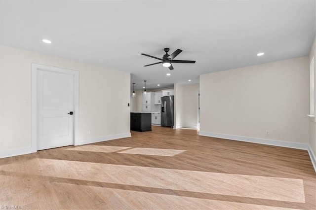 unfurnished living room with ceiling fan and light wood-type flooring