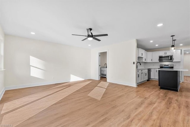 interior space with ceiling fan, sink, and light hardwood / wood-style flooring