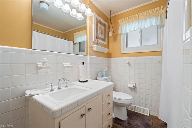 2505 Roland Rd, Greensboro, NC 27407 - bathroom featuring vanity, tile walls, ornamental molding, plenty of natural light, and wainscoting
