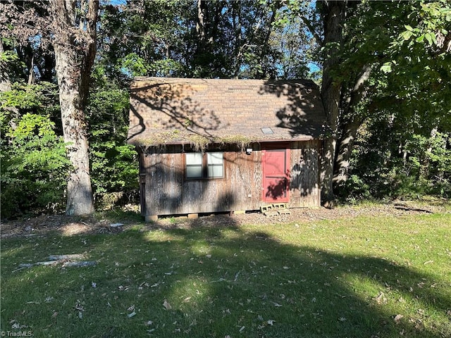 view of property exterior featuring a lawn and an outbuilding