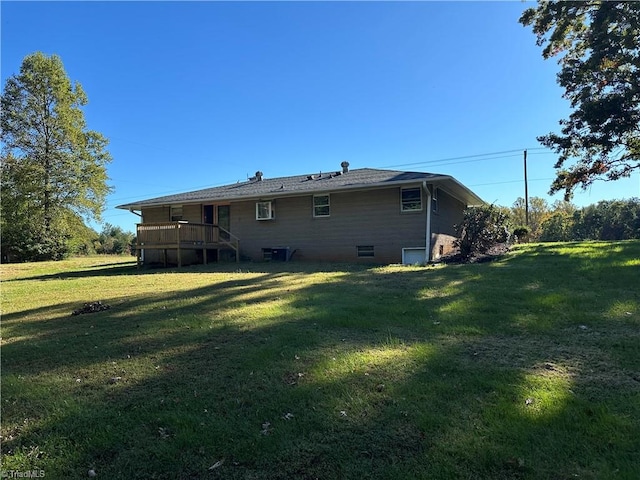 back of property with a deck and a lawn