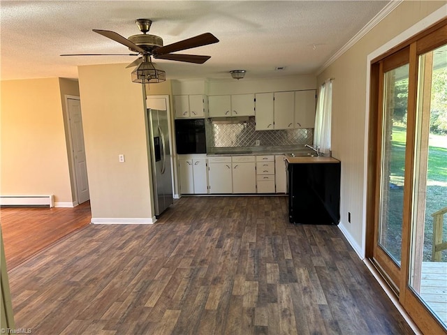 kitchen featuring tasteful backsplash, black appliances, dark hardwood / wood-style flooring, baseboard heating, and crown molding