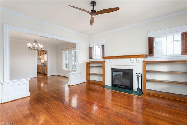 unfurnished living room featuring hardwood / wood-style floors, ceiling fan with notable chandelier, and ornamental molding