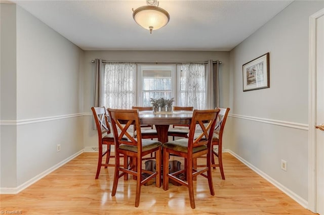 dining area with light wood-type flooring and baseboards