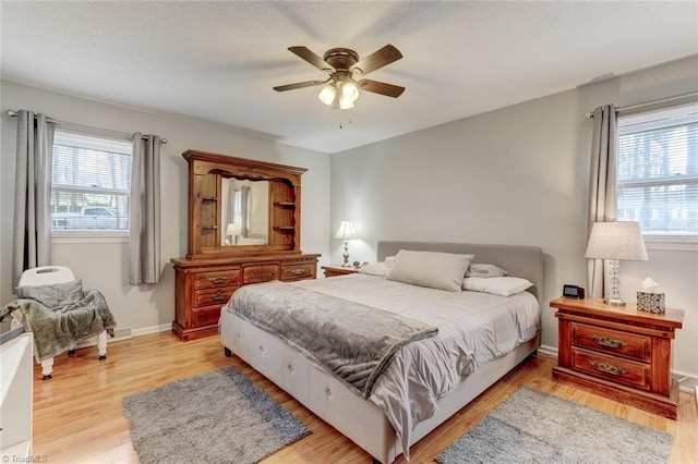 bedroom featuring light wood-style flooring, baseboards, and ceiling fan