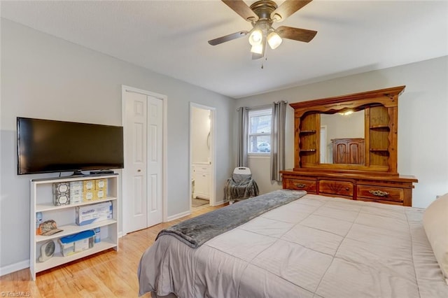 bedroom with baseboards, ceiling fan, wood finished floors, and connected bathroom