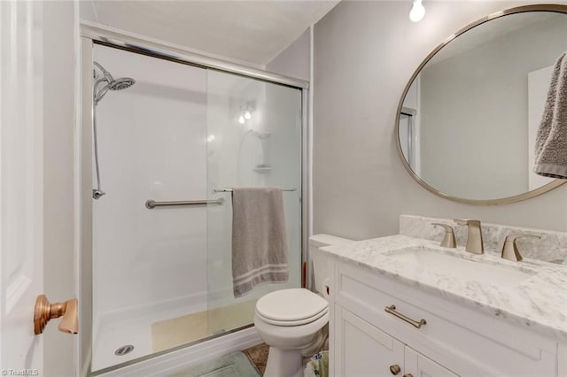 bathroom featuring a stall shower, vanity, and toilet