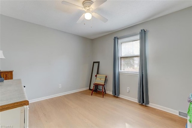 unfurnished room with visible vents, baseboards, a ceiling fan, and light wood-style floors