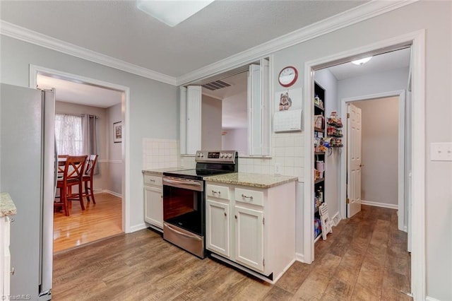 kitchen featuring visible vents, white cabinets, stainless steel appliances, light wood-type flooring, and backsplash